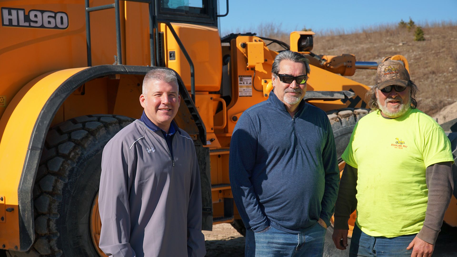 Ed Harseim, HCEA North Central District Manager, Jon Christine, Yes Equipment, Sales, and Jim Farrel, Kohler Pit, Operator, Stand In Front of the Hyundai HL960 Wheel Loader